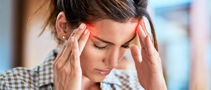 Woman with headache holding temples in pain