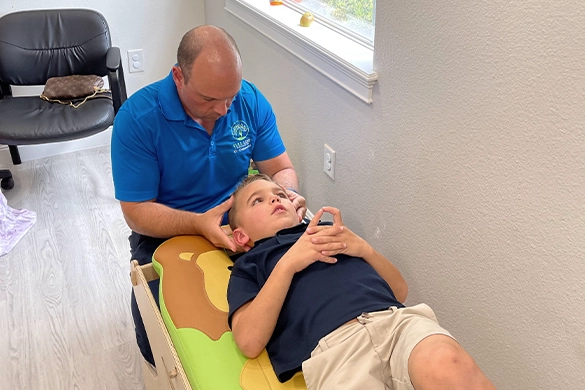 Chiropractor Lutz FL Enrico Dolcecore Adjusting Pediatric Patient